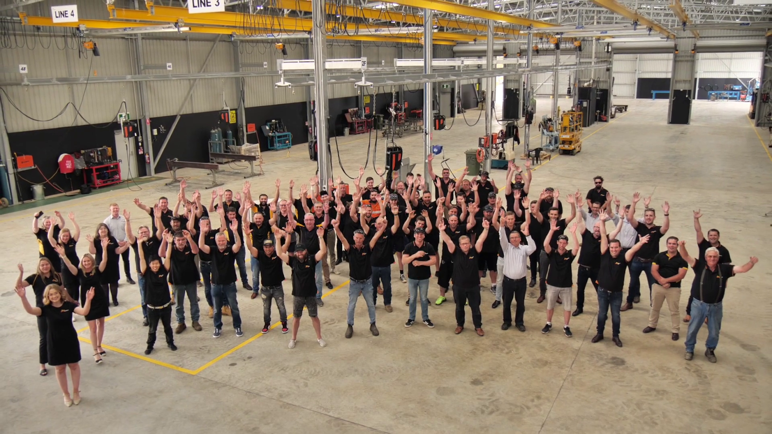 AUSPAN team in shed waving at camera